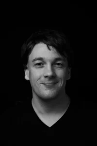 Portrait eines dunkelhaarigen Mannes der nett lächelt