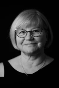 Schwarz weiss Fotografie einer älteren Frau mit Brille und Kette